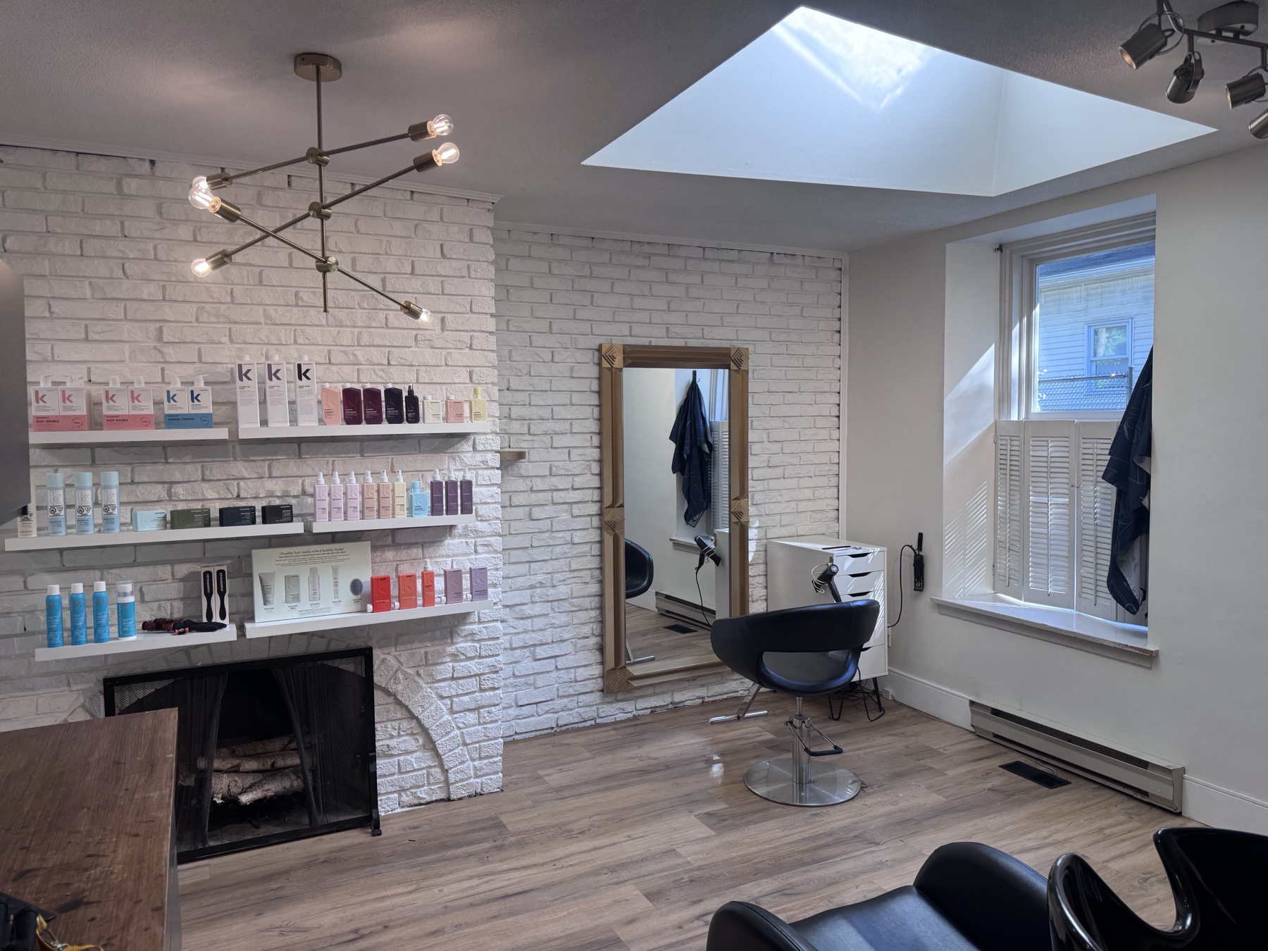 Inside 91 Waterloo salon — white brick, fireplace, styling stations